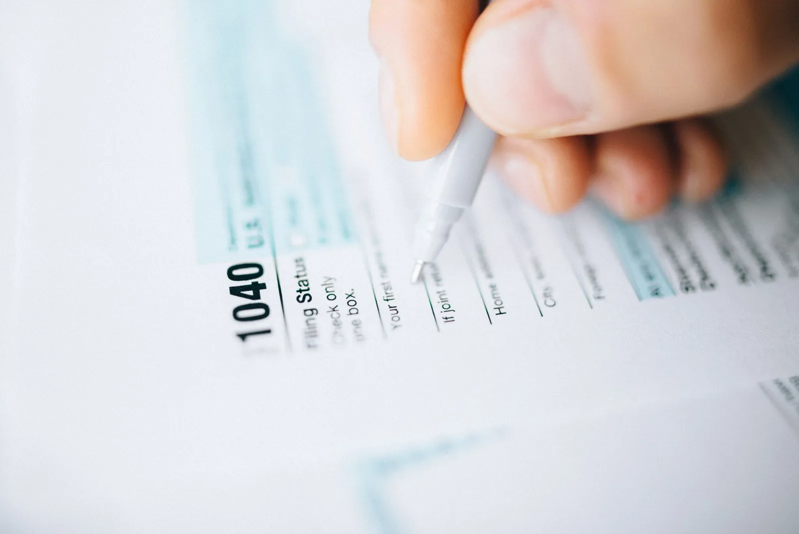 Un contribuable consulte son avis d'impôt sur un ordinateur portable, calculatrice posée sur le bureau